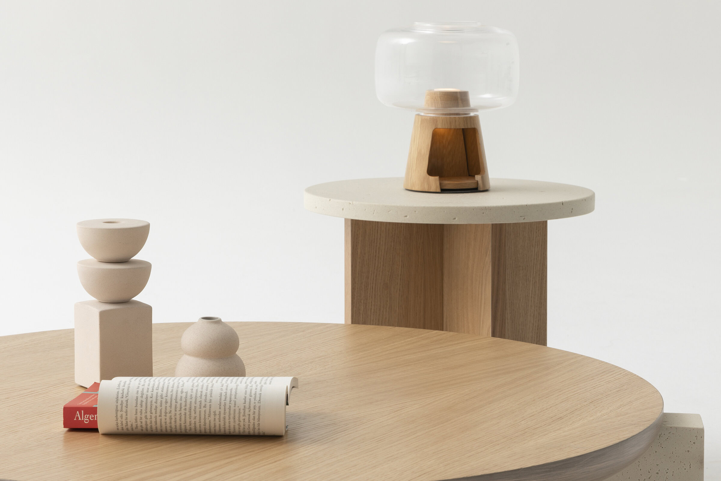 Minimalist wooden and concrete side table decor with glass vessel and ceramic vases, showcasing modern furniture design by Saloni Furniture.